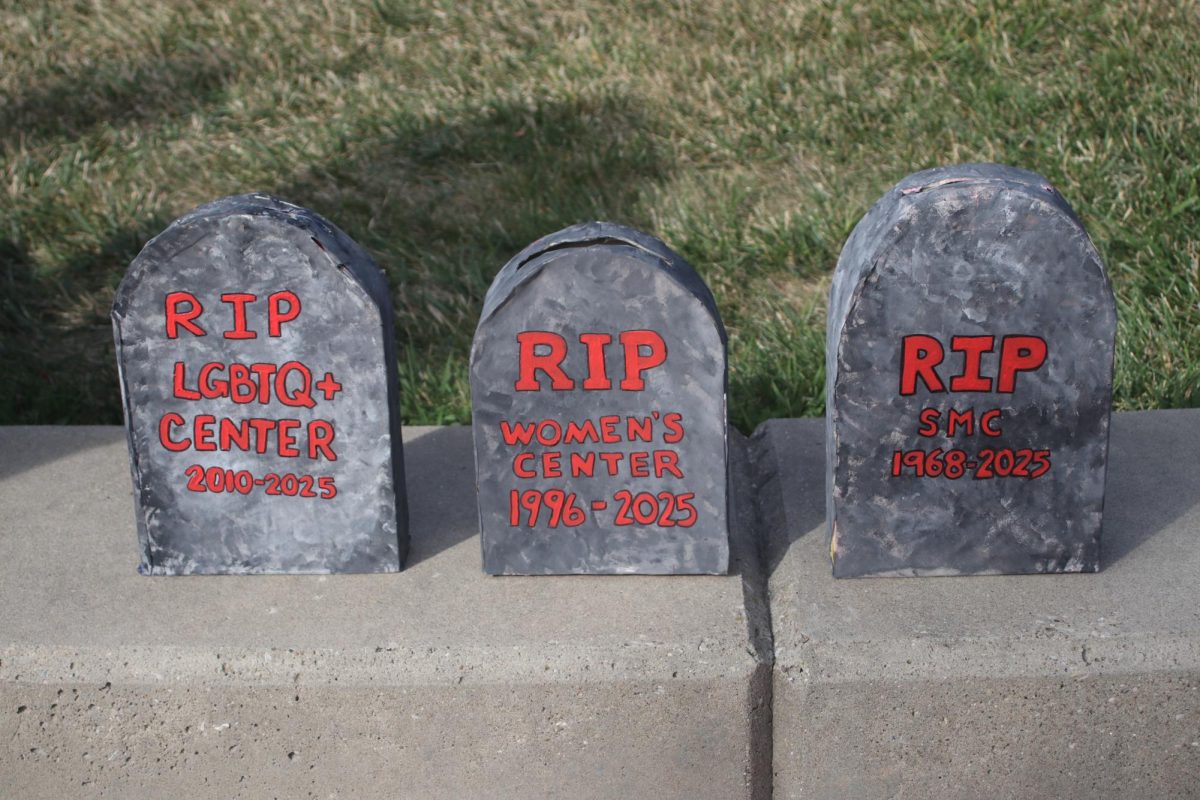 The LGBTQ+ Center, Women's Center and Student Multicultural Center are remembered through gravestones at a funeral-themed protest Aug. 27, 2025.